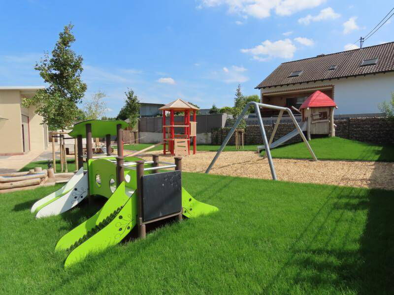 Kindergarten Spielplatz mit vielen Spielgeräten (Schaukel, Rutsche, Klettergerüst)