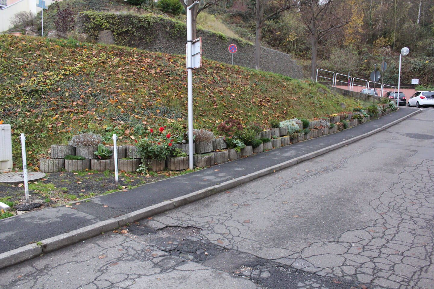 Der Asphalt der Straße und Gehwege ist marode und hat Risse und Schlaglöcher.