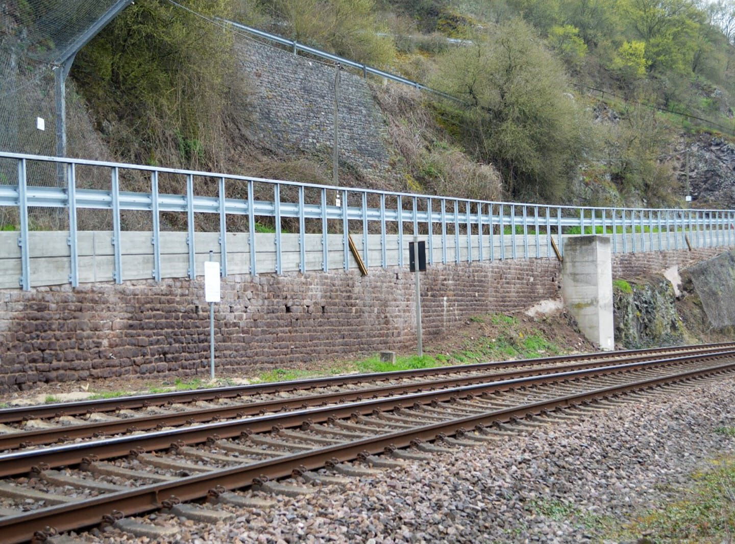 Bahngleisen mit sanierter Stützmauer