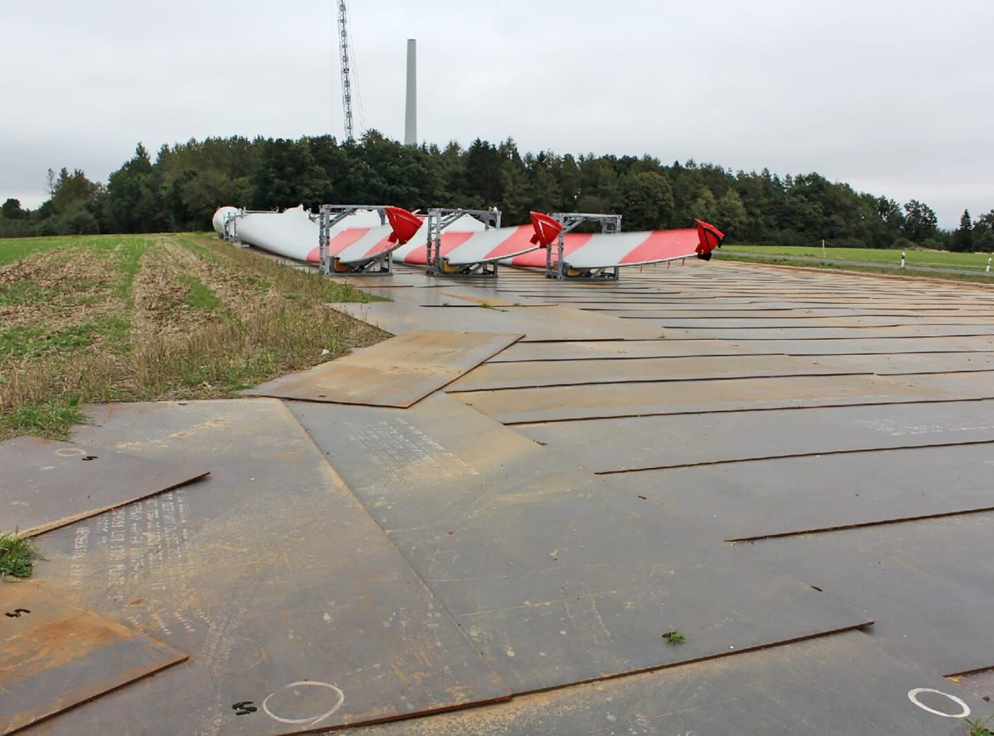 Drei Rotorenblätter eines Windrades liegen bereit